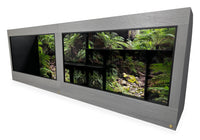 12'x2.5'x4' two-section reptile enclosure with Driftwood gray woodgrain HDPE front frame and black PVC body. Options shown: 10-inch lower frame, Blue Mountains Destinations background and custom shelves.