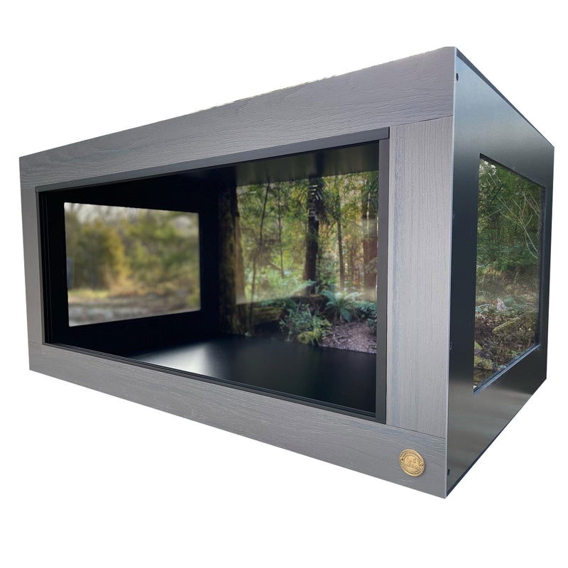 Extra Wide Reptile Enclosure featuring HDPE Driftwood front frame paired with Black PVC body panels. Shown with Australian Temperate Rainforest Destinations Reptile Cage Background and two 15x15 side windows.